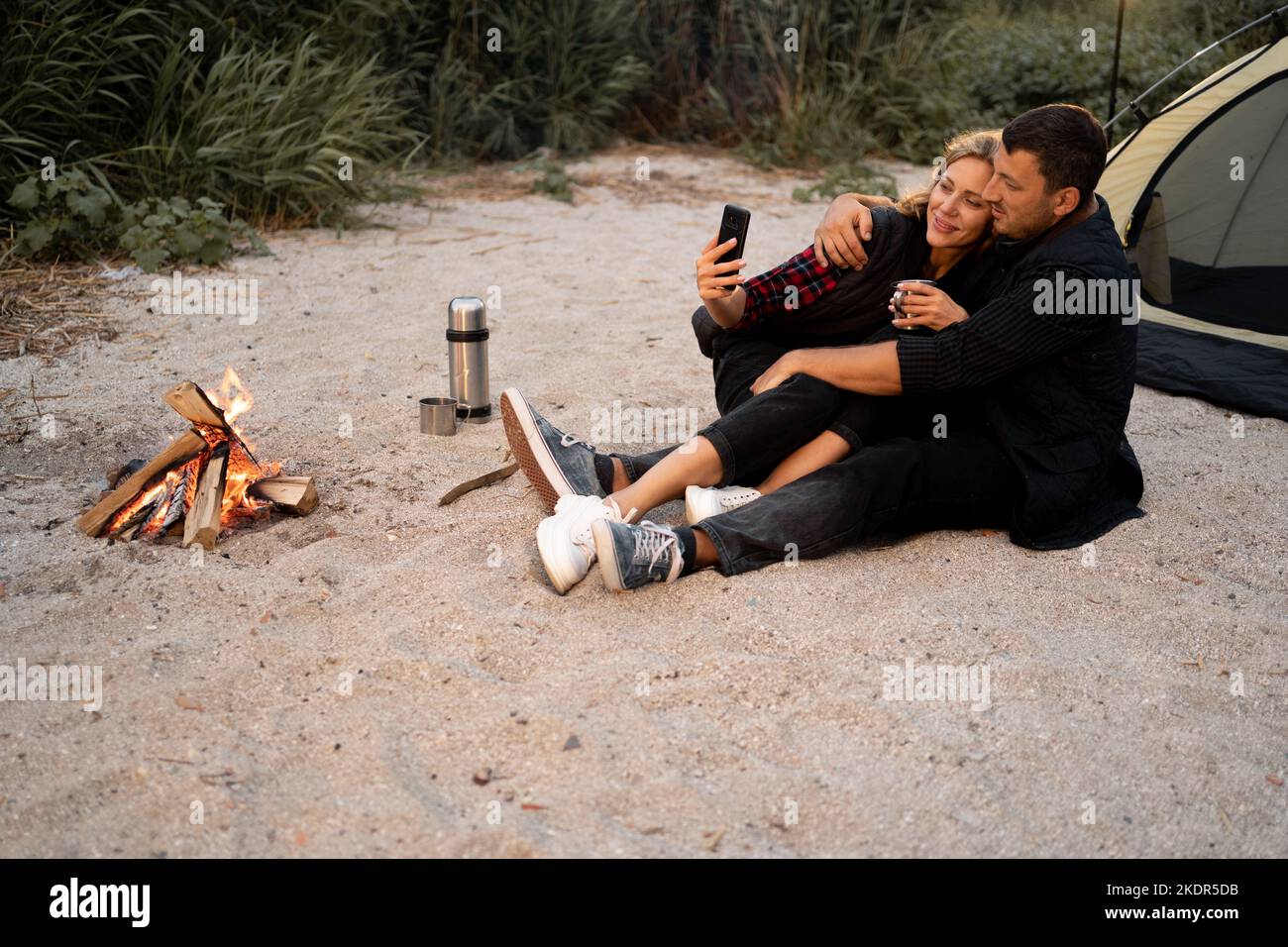 Camping couple in a tent taking a selfie. Happy couple making selfie