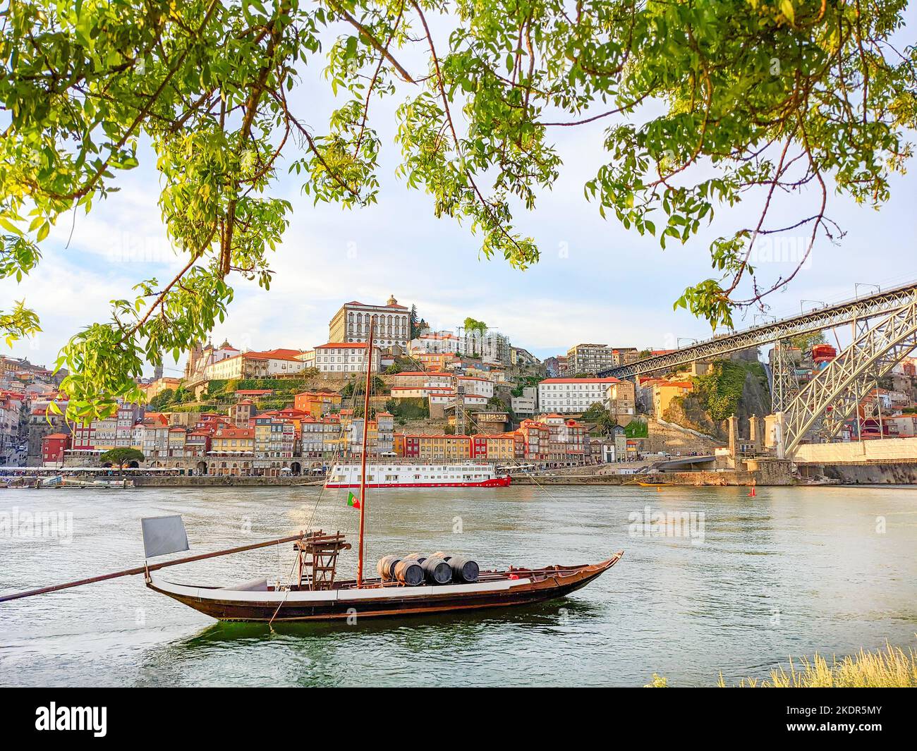 Traditional wine boat, Ribeira embankment in bakground, Dom Luis bridge, Porto, Portugal Stock Photo