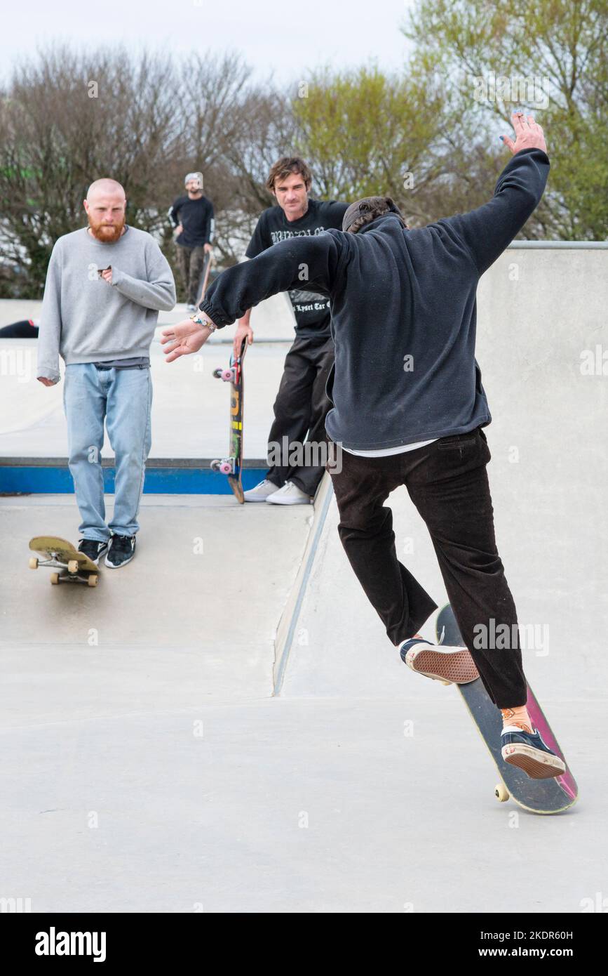 A male skateboarder performing an ollie trick at Newquay Concrete Waves Skatepark in Newquay in Cornwall in the UK. Stock Photo