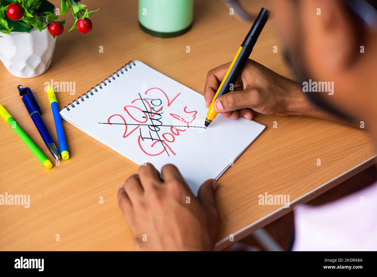 Shoulder shot of young man scratching 2022 new year Goal teardown paper - concept of failure, angry and missed goal Stock Photo