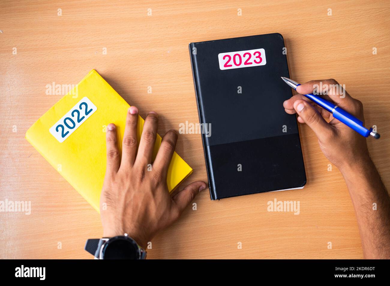 Top view of hands replacing 2022 old Diary with New year 2023 dairy on