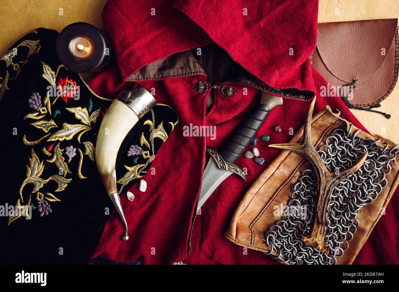 Fantasy live action role play game concept. Background decorated with various character objects tools: Dagger, chain mail, cape, clothing, horn. Stock Photo