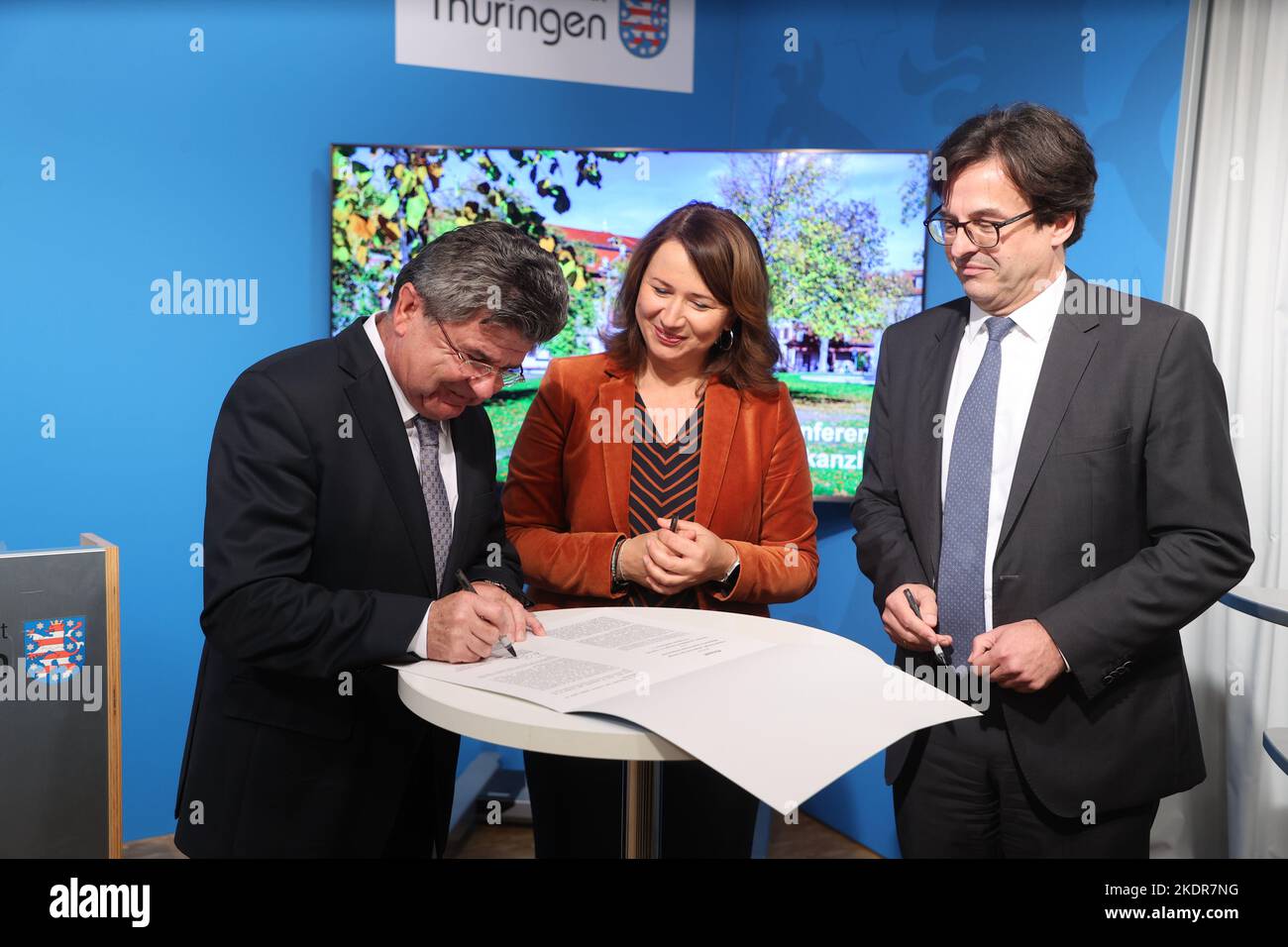 Erfurt, Germany. 08th Nov, 2022. Michael Brychcy, (l-r) President of the Association of Municipalities and Towns of Thuringia, Anja Siegesmund, (Bündnis 90/Die Grünen), Thuringia's Minister for the Environment, Energy and Nature Conservation and Thomas Budde, Managing Director of the Thuringian County Association sign the climate package at a government press conference on the new climate package. Siegesmund will also report on the extension of Thuringia's membership in the regional climate protection network (Under2-Coalition). Credit: Bodo Schackow/dpa/Alamy Live News Stock Photo