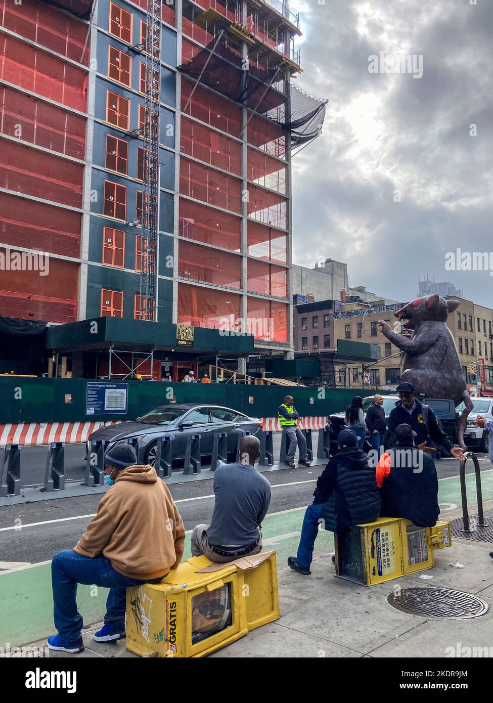Sidewalk “superintendents” observe the inflatable Union rat outside affordable housing construction in Chelsea  in New York on Wednesday, October 26, 2022. (© Frances M. Roberts) Stock Photo