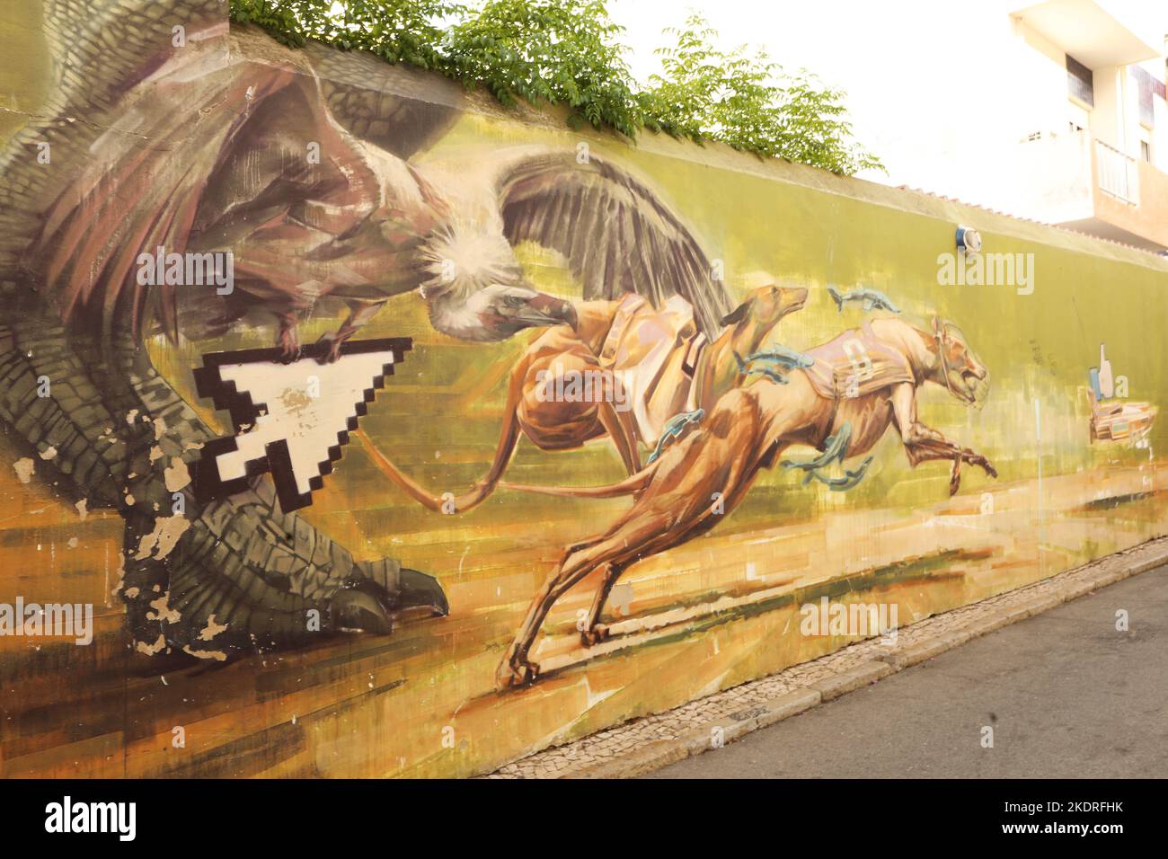 A mural of two greyhounds and an eagle chasing a power boat on a wall in old town, Lagos, Algarve, Portugal Stock Photo