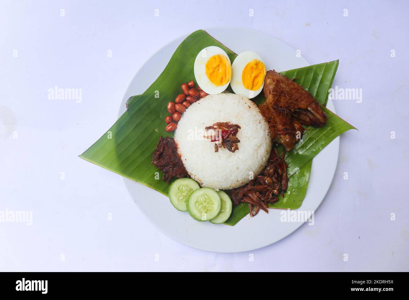 nasi lemak, is traditional malay made boiled eggs, beans, anchovies, chili sauce, cucumber. isolated on white background Stock Photo