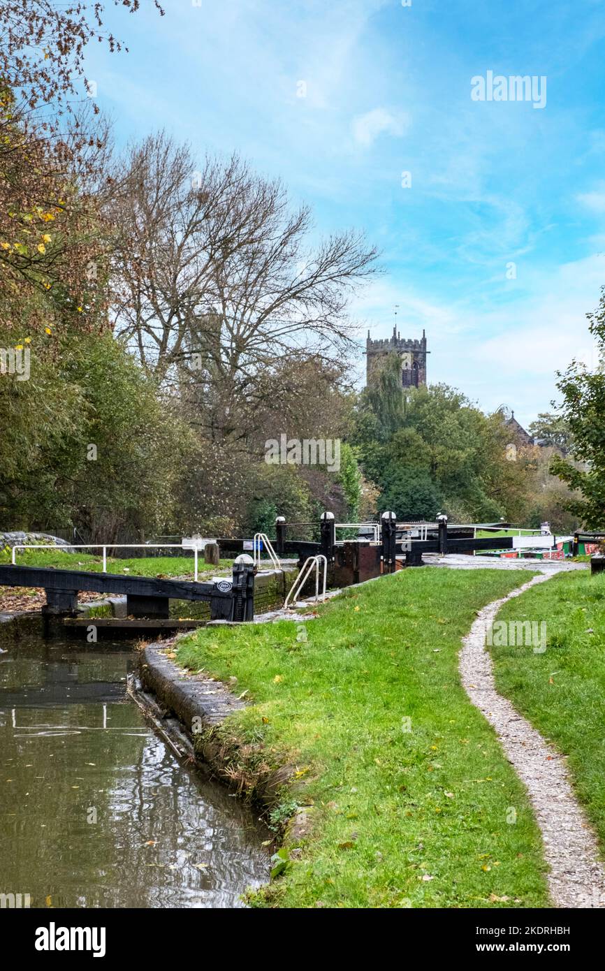 Narrow boats with lock on the Trent & Mersey canal with St Michael Church in distance, Middlewich Cheshire UK Stock Photo