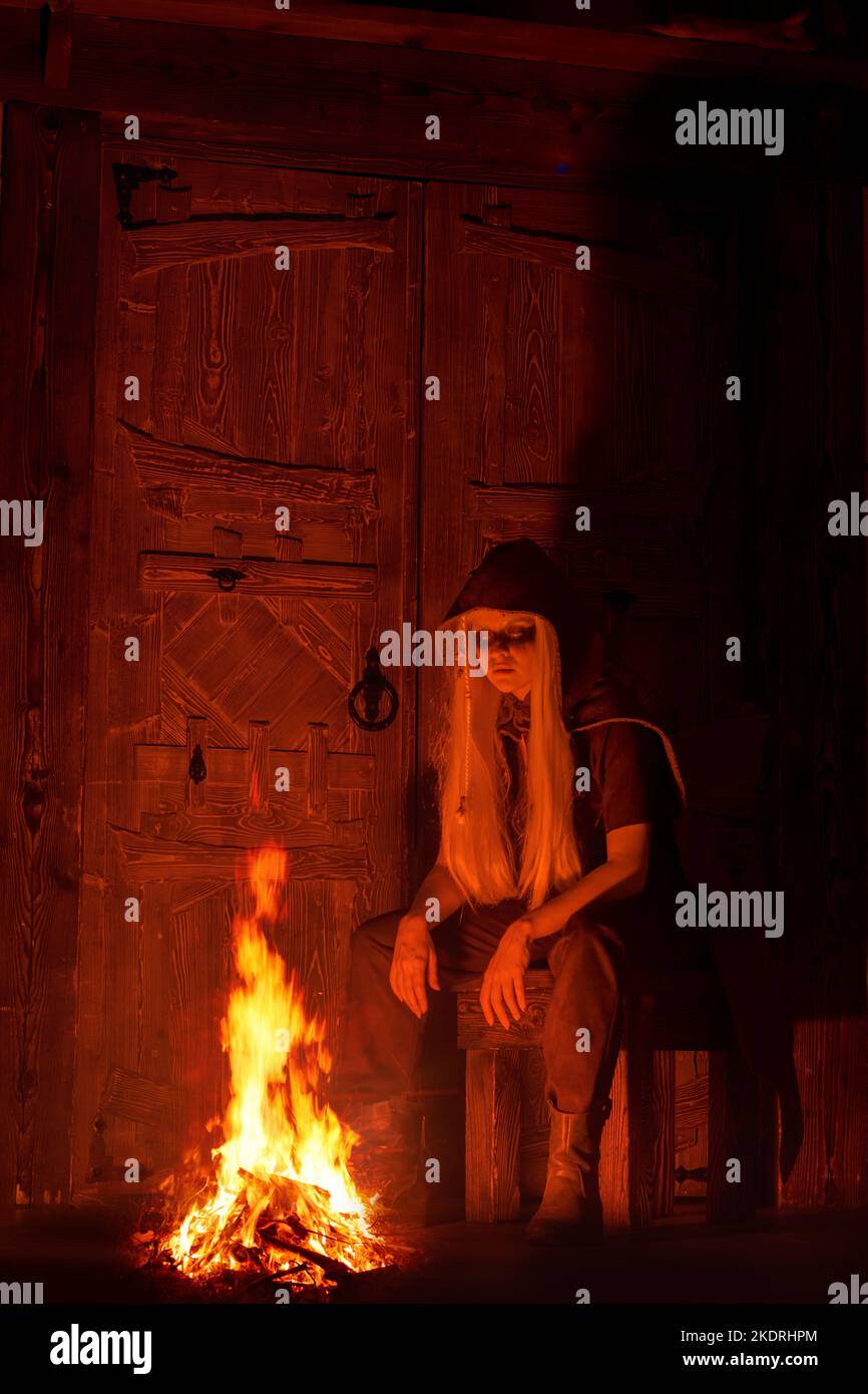 Viking woman in traditional warrior clothes. Viking woman inside wooden hut. Stock Photo