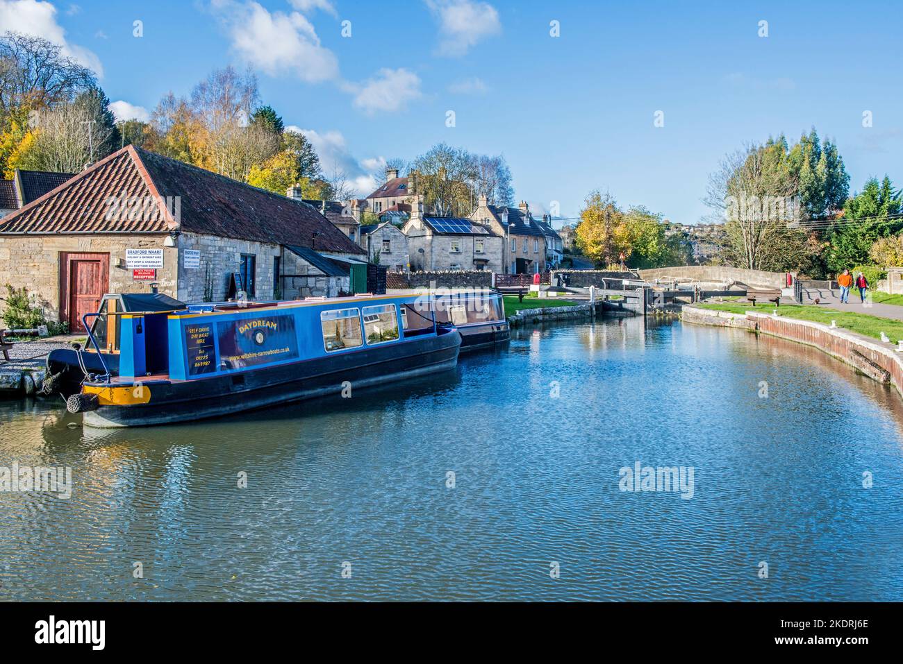 The Bradford and Avon canal at Bradford on Avon in West Wiltshire with a narrowboat moored up near the bridge and lock gates Stock Photo
