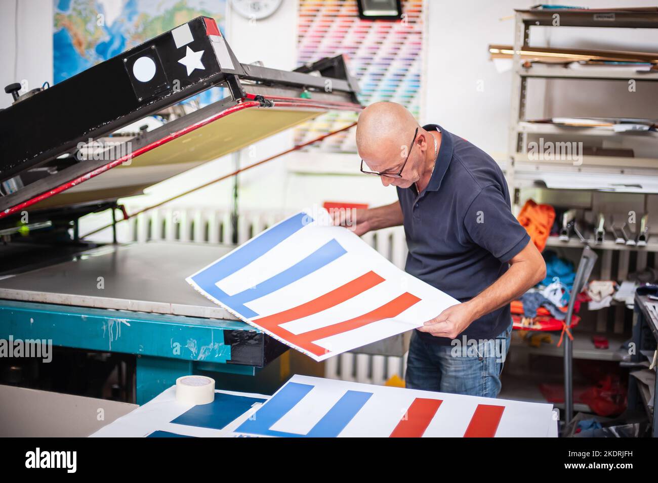 In the printing house, an experienced technician works on a screen