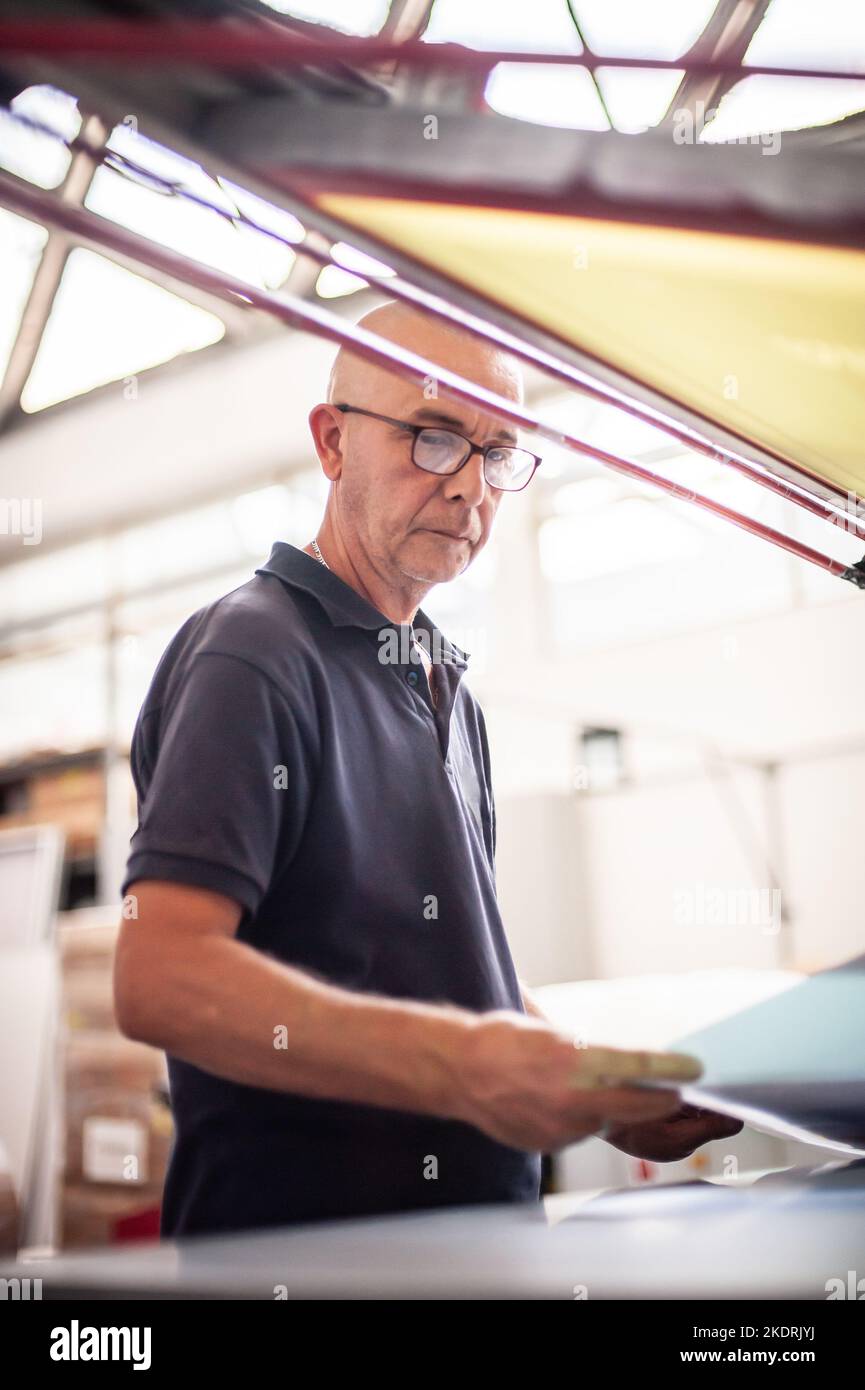 In the printing house, an experienced technician works on a screen
