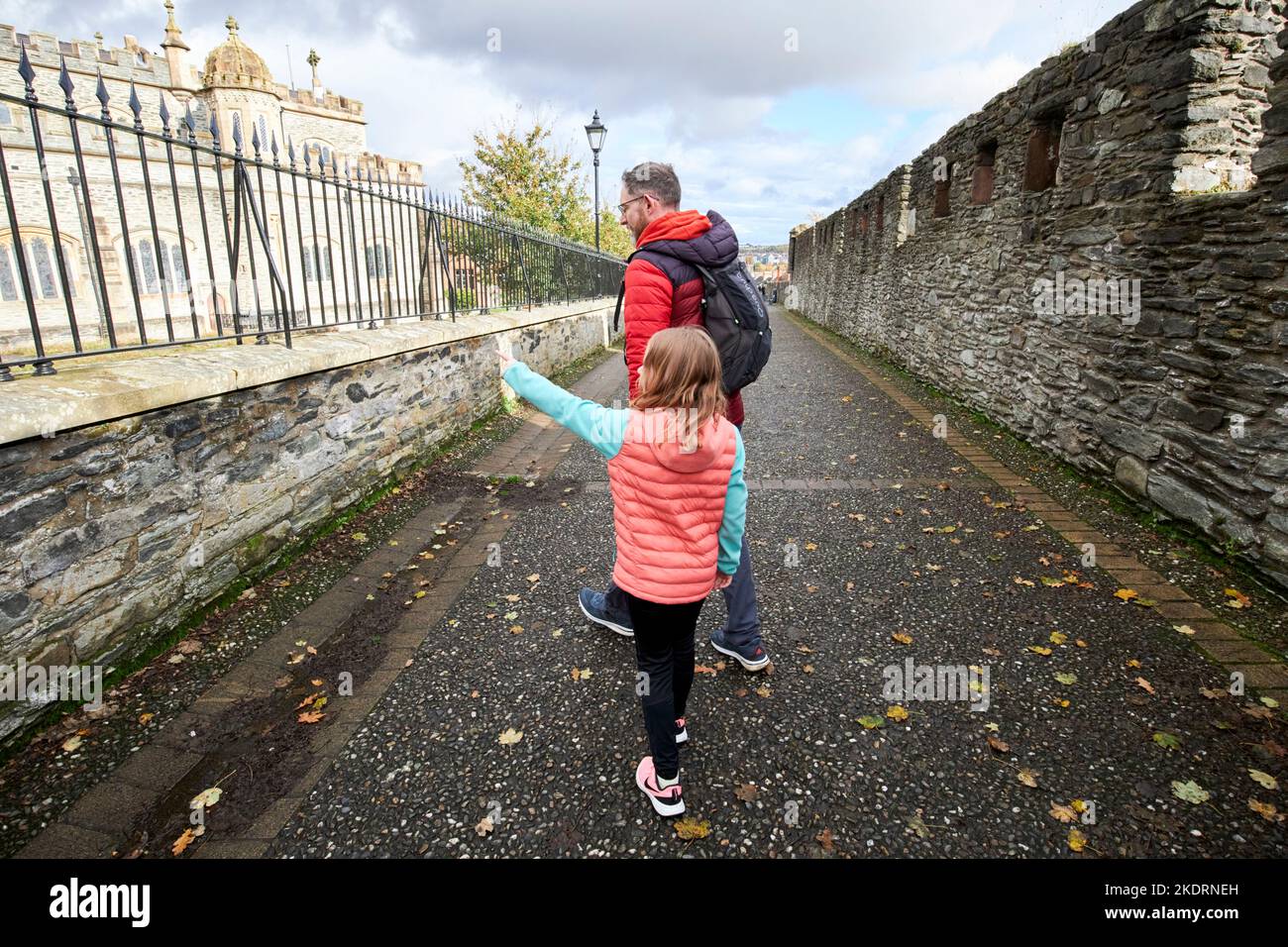 dad and daughter walking along the church wall section of derrys walls derry londonderry northern ireland uk Stock Photo