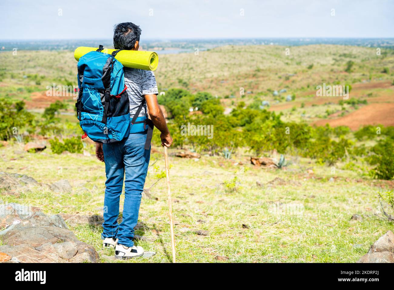 Back view shot of middle aged hiker getting down from mountian top - concept of wellbeing, hobby and freedom. Stock Photo