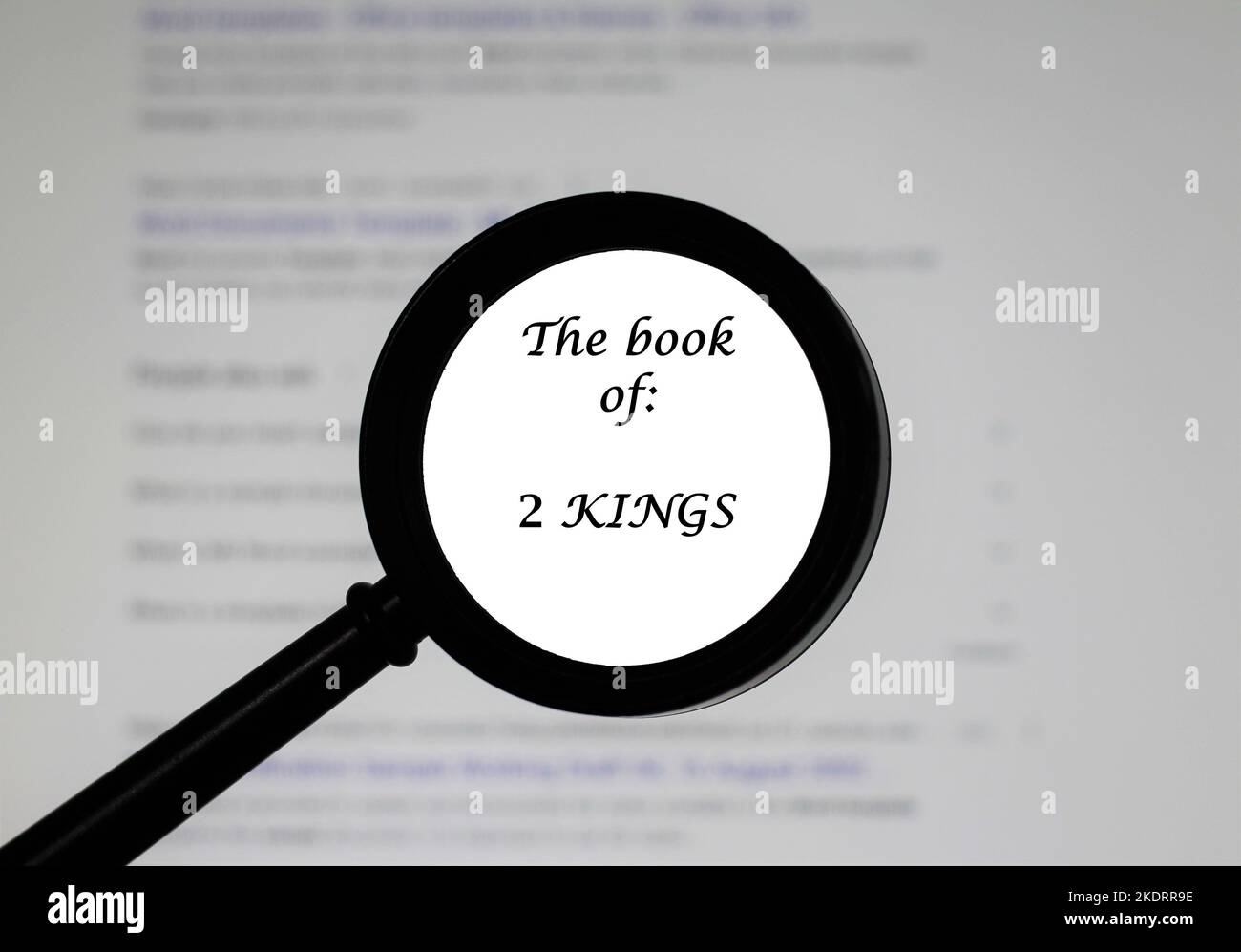 The Book of 2 Kings from the Holy Bible, illustrated inside a magnifying class, zoomed in. Stock Photo