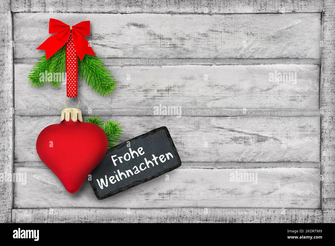 Frohe Weihnachten und Dekoration mit rotem Herz und Tannenzweigen auf Holz Stock Photo