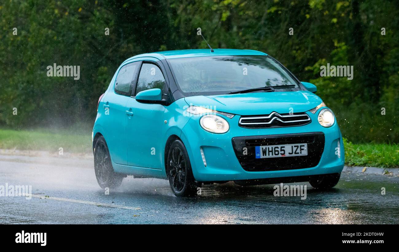 Turquoise 2016 Citroen C1 hatchback car driving in the rain Stock Photo