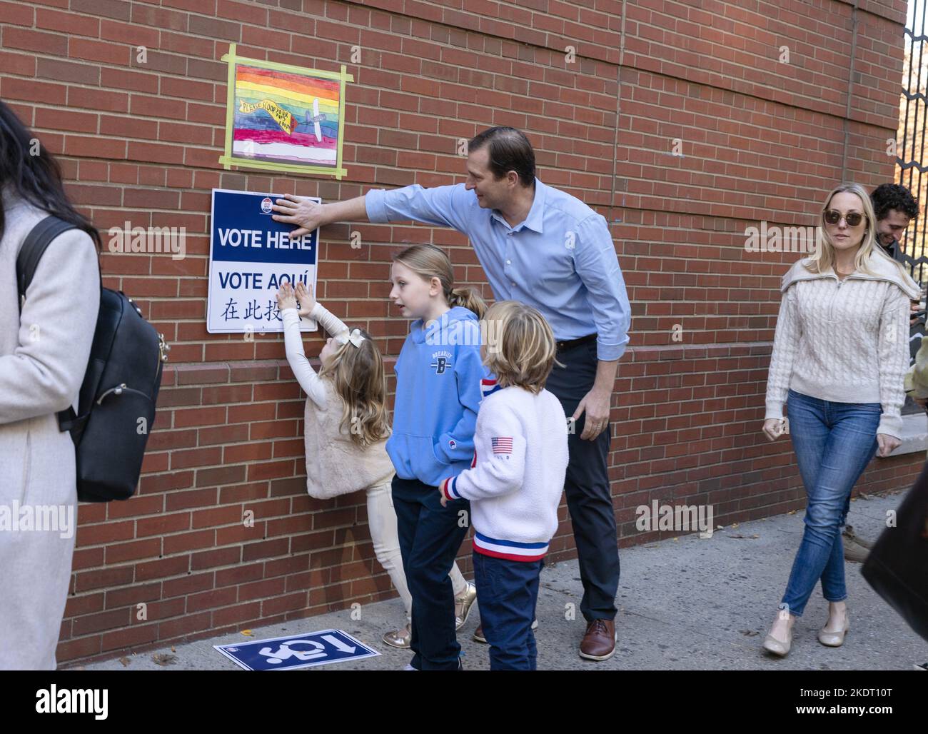 NEW YORK, N.Y. – November 8, 2022: Congressional candidate Dan Goldman repairs a sign while waiting with his family to vote on Election Day 2022. Stock Photo