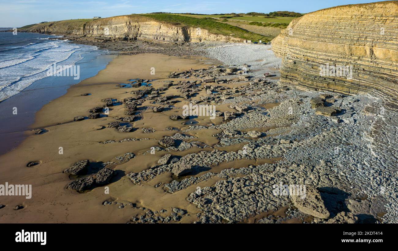 Aerial view of large limestone cliffs and a sandy beach next to the ocean Stock Photo