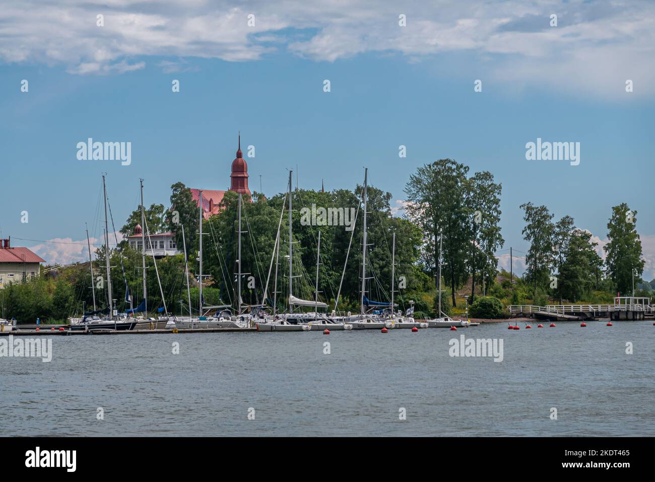 Helsinki, Finland - July 19, 2022: Yacht harbor with Restaurant Saaristo tower on Klippan Island under blue cloudscape. Green trees separate both Stock Photo