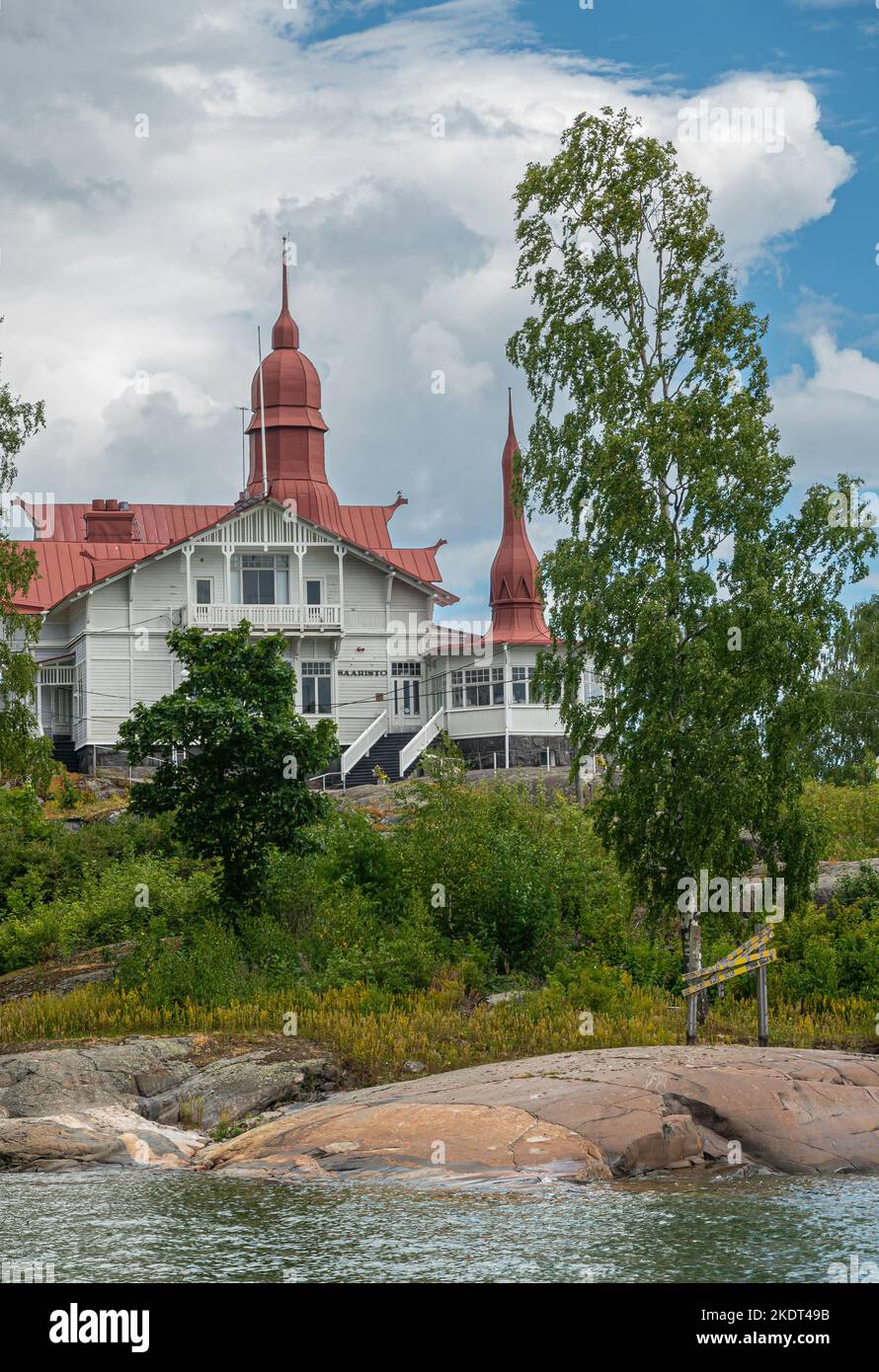 Helsinki, Finland - July 19, 2022: Portrait, Red roofed Restaurant Saaristo on its own green klippan island under blue cloudscape. Stock Photo