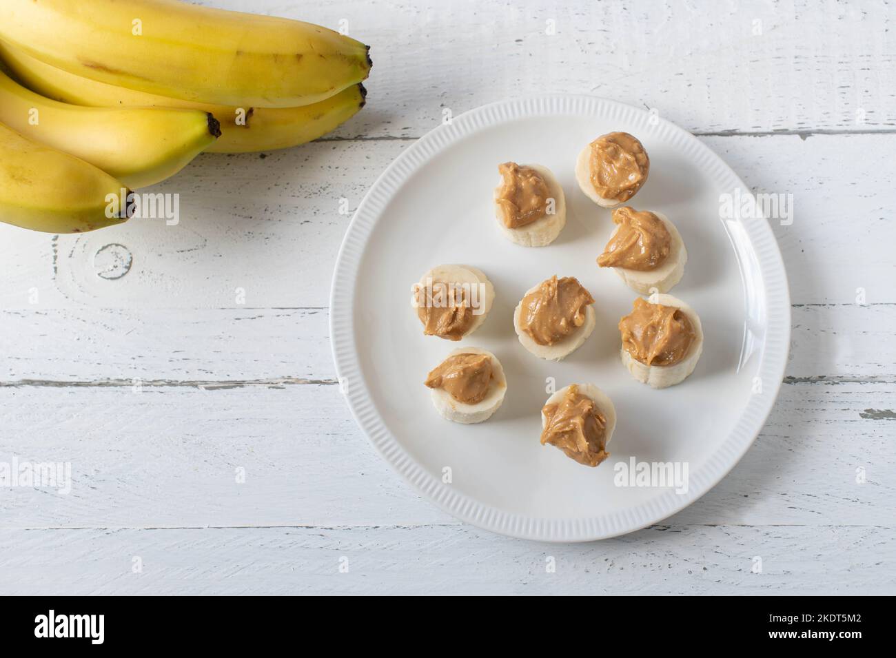 Banana with peanut butter topping on a plate Stock Photo