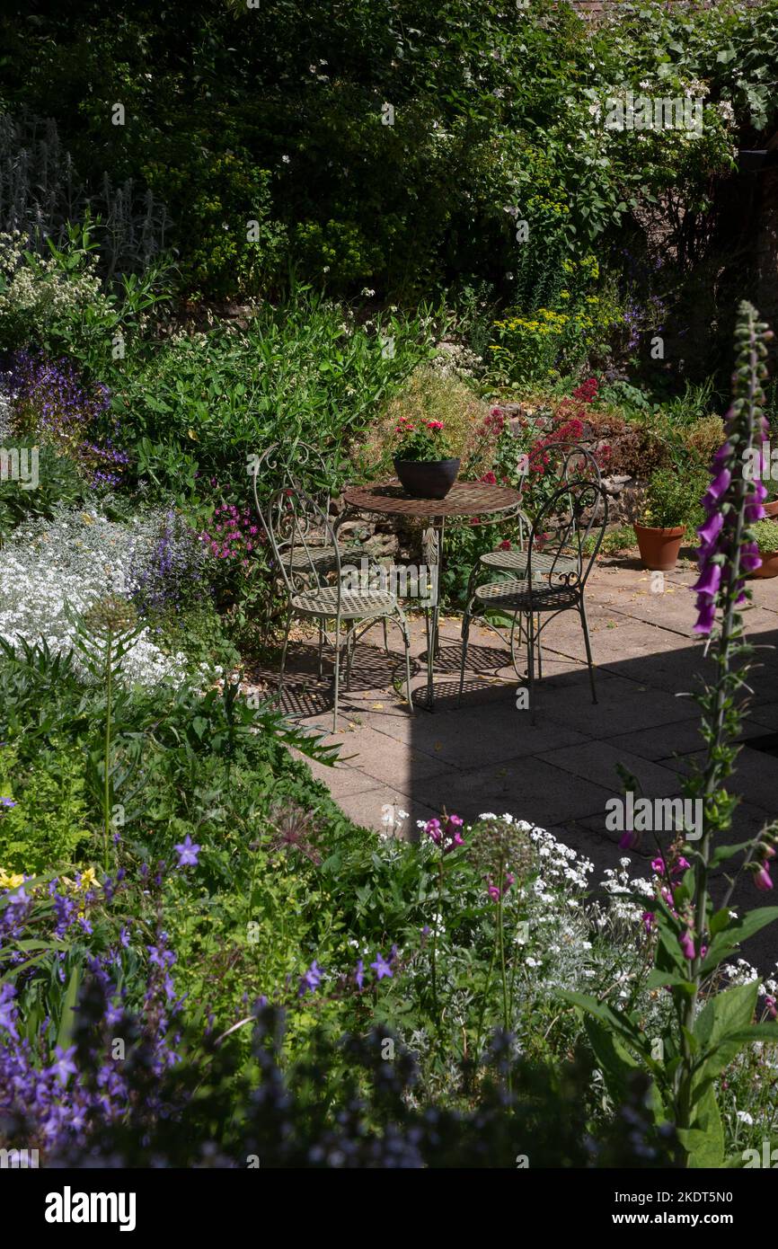 Metal garden chairs and table on patio in english summer , england Stock Photo
