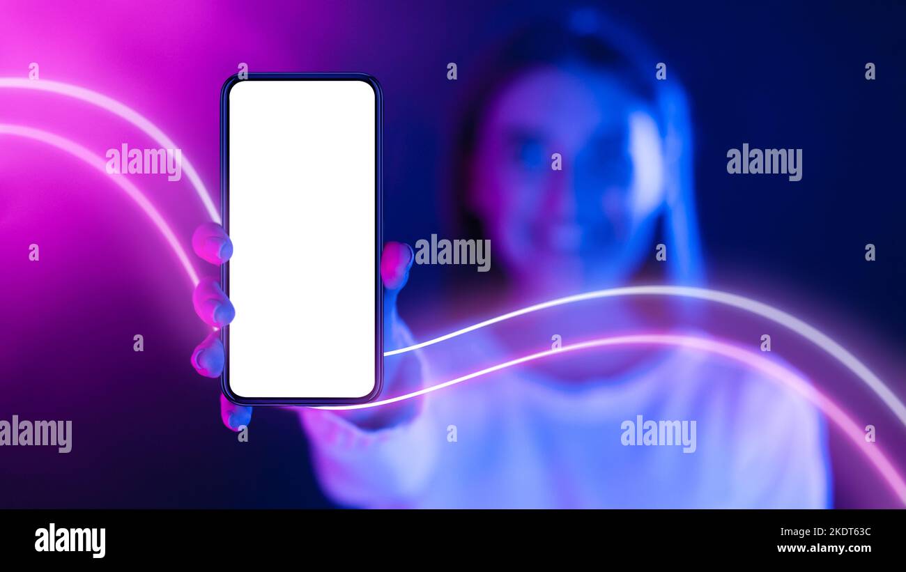 Happy long-haired woman showing smartphone with empty screen, copy space Stock Photo