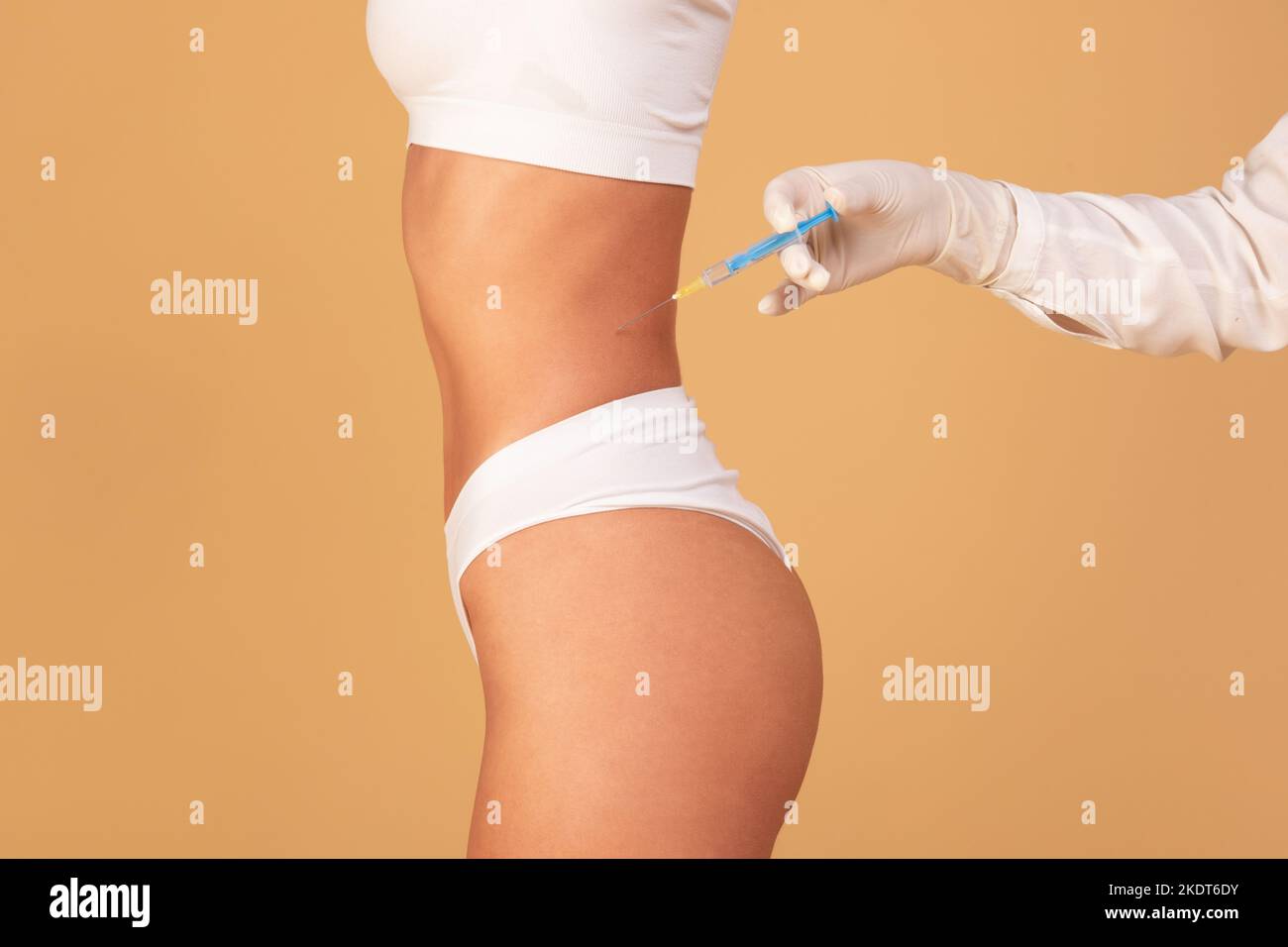 Beauty treatment concept. Cropped view of young fit woman getting injection in belly area, having procedure in salon Stock Photo