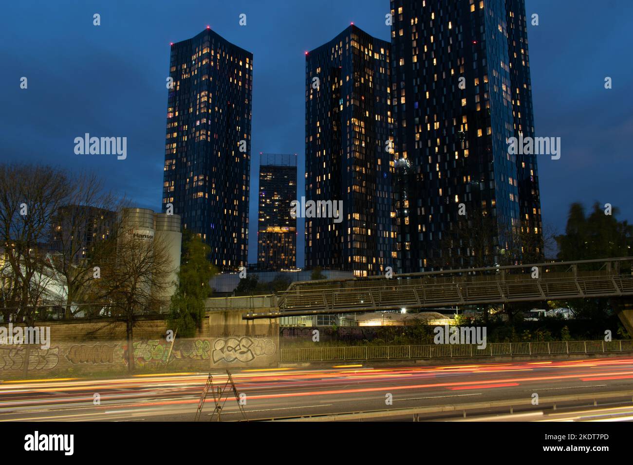 Deansgate Square tower blocks at twilight. Manchester UK. Long exposure with light trails from traffic. Stock Photo
