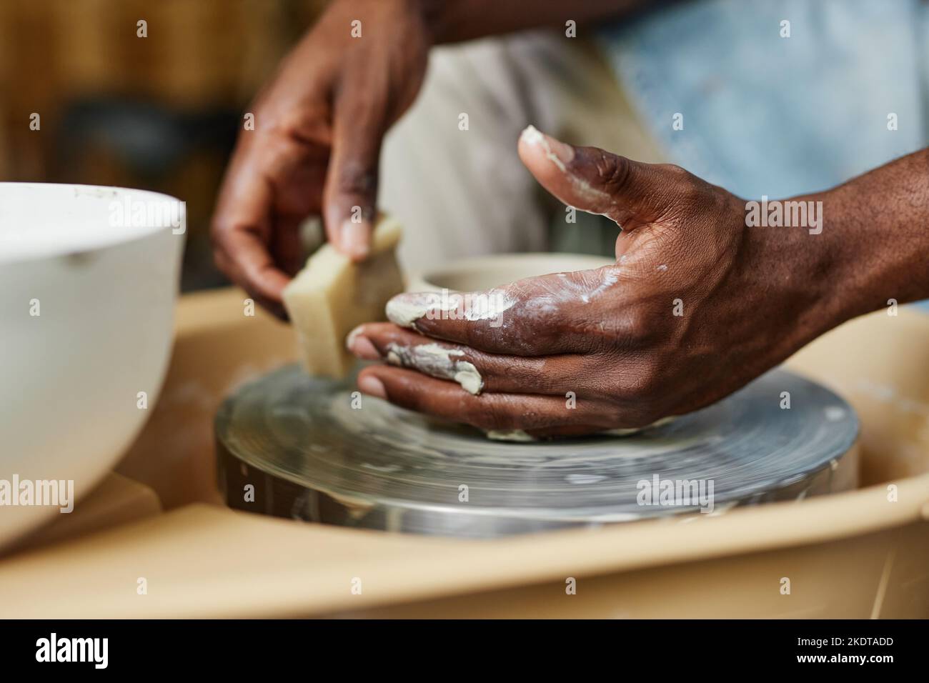 Close up of male hands using pottery wheel and creating handmade ceramics in art class Stock Photo