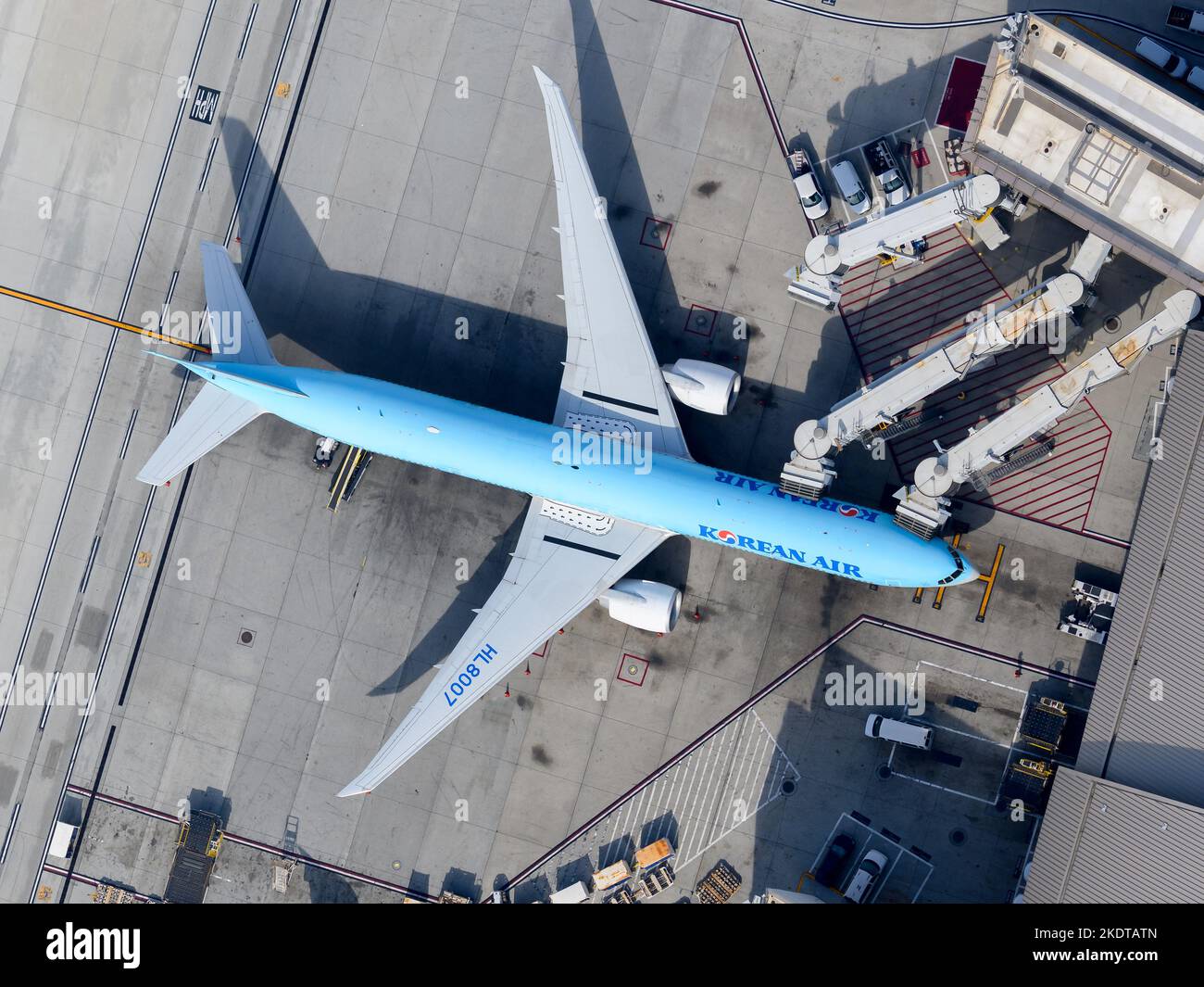 Korean Air Boeing 777 aircraft from above. Airplane 77W of Korean Air connected to boarding jet bridges. Plane 777-300ER of Korean Air HL8007. Stock Photo