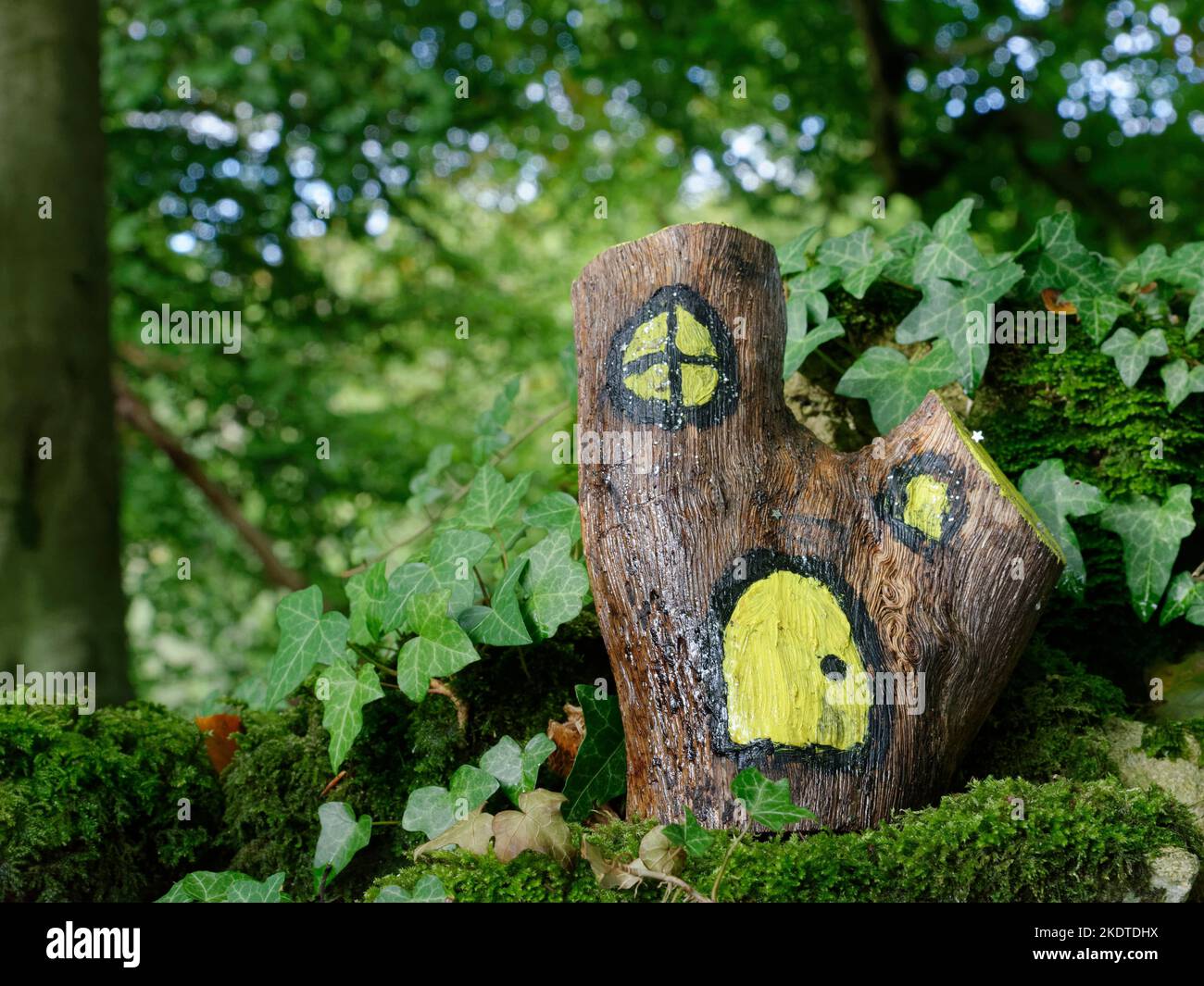 Fairy log home on an old moss covered wall, near Castle Combe, Wiltshire, UK, October 2022. Stock Photo