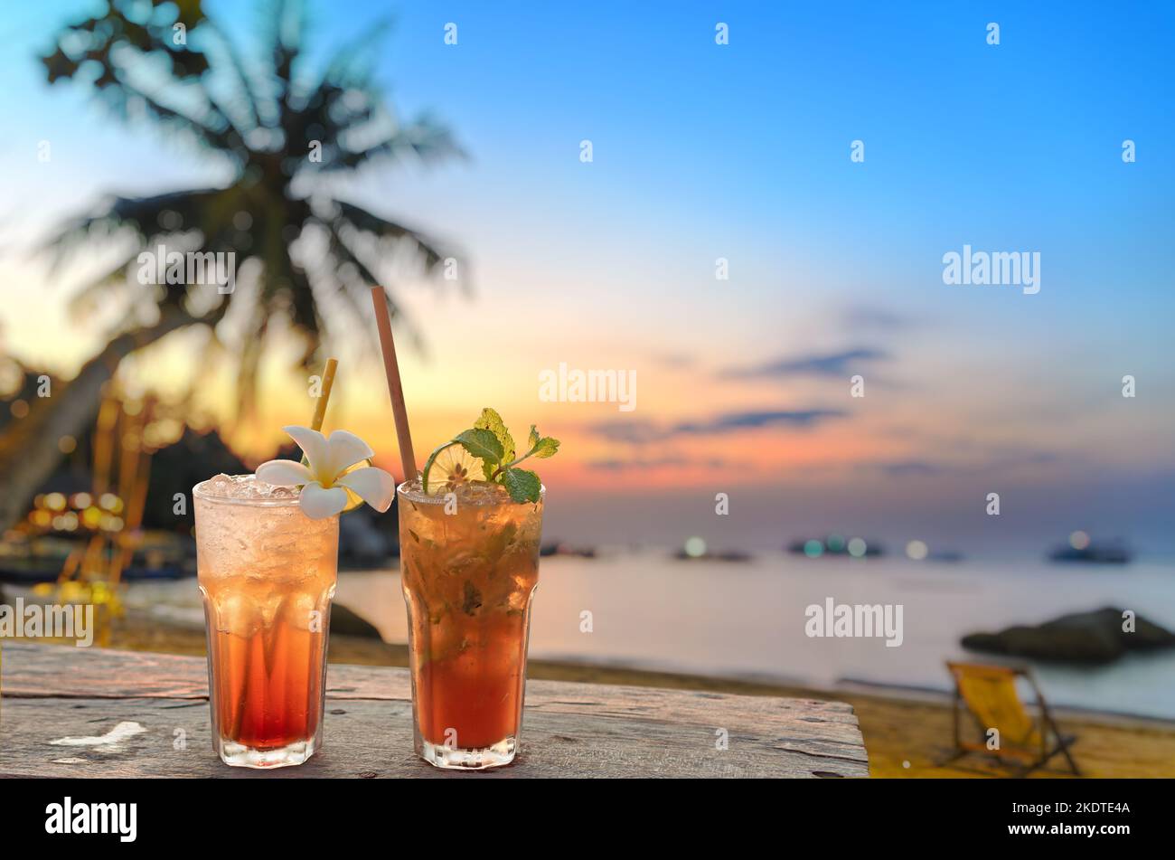 drinks with blur beach and sunset in background Stock Photo