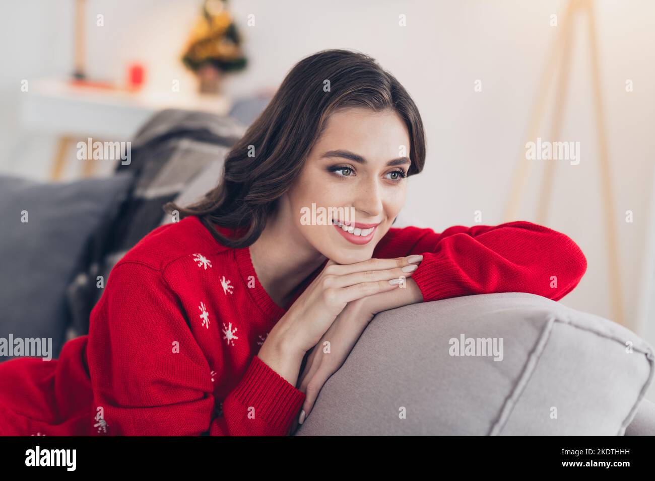 Photo of nice cute pretty adorable lady sitting couch indoors room enjoy cozy day magic time look out window admire shiny frosty day Stock Photo