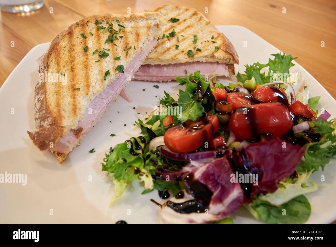 toasted ham and cheese sandwich with salad out of focus in a cafe derry londonderry northern ireland uk Stock Photo