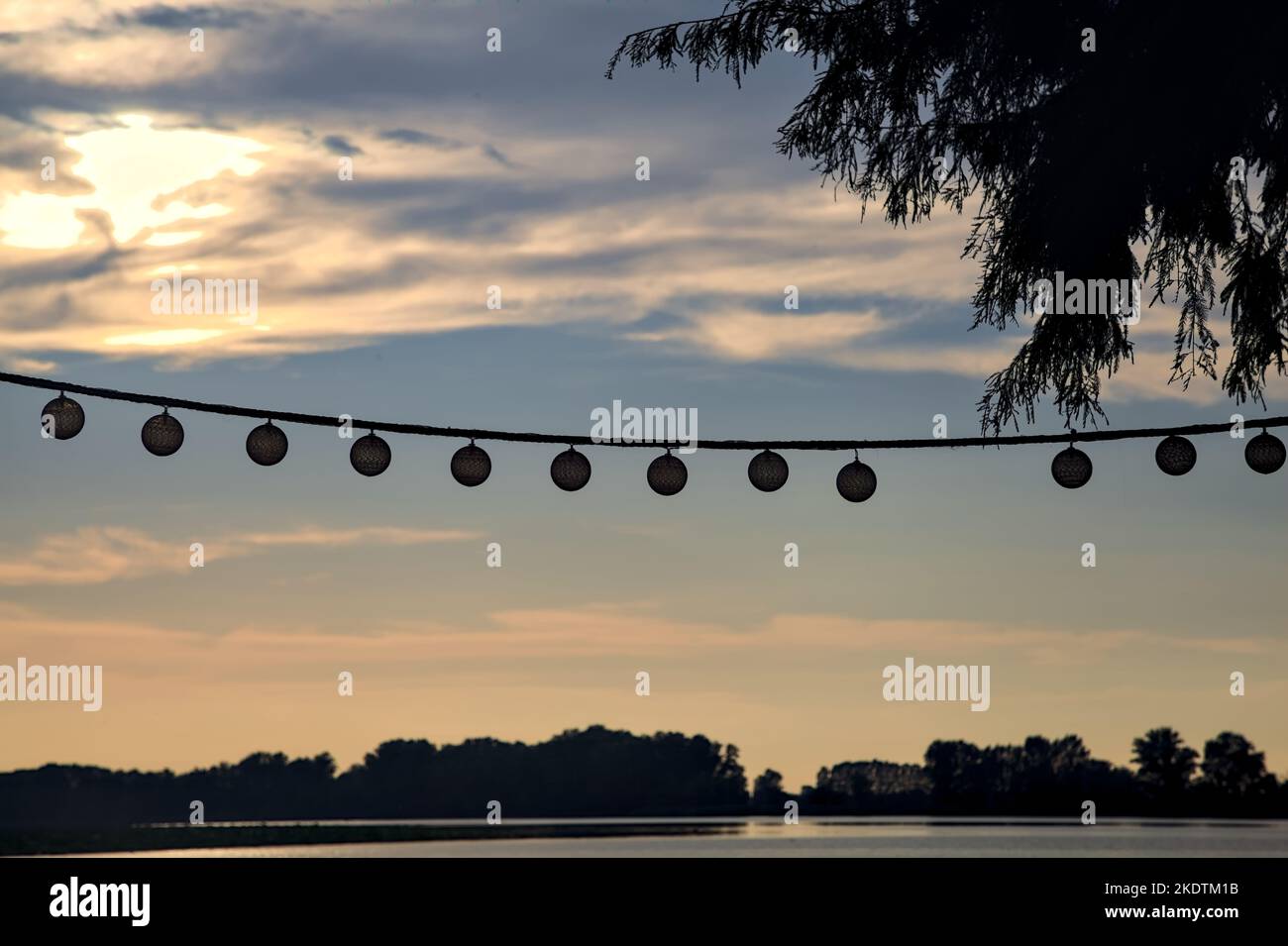 Lights  hanging on a rope with the sunset sky as background Stock Photo