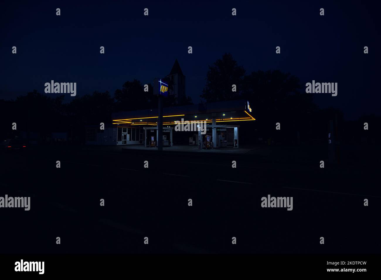 IP  branded fuel station in a town at dusk Stock Photo