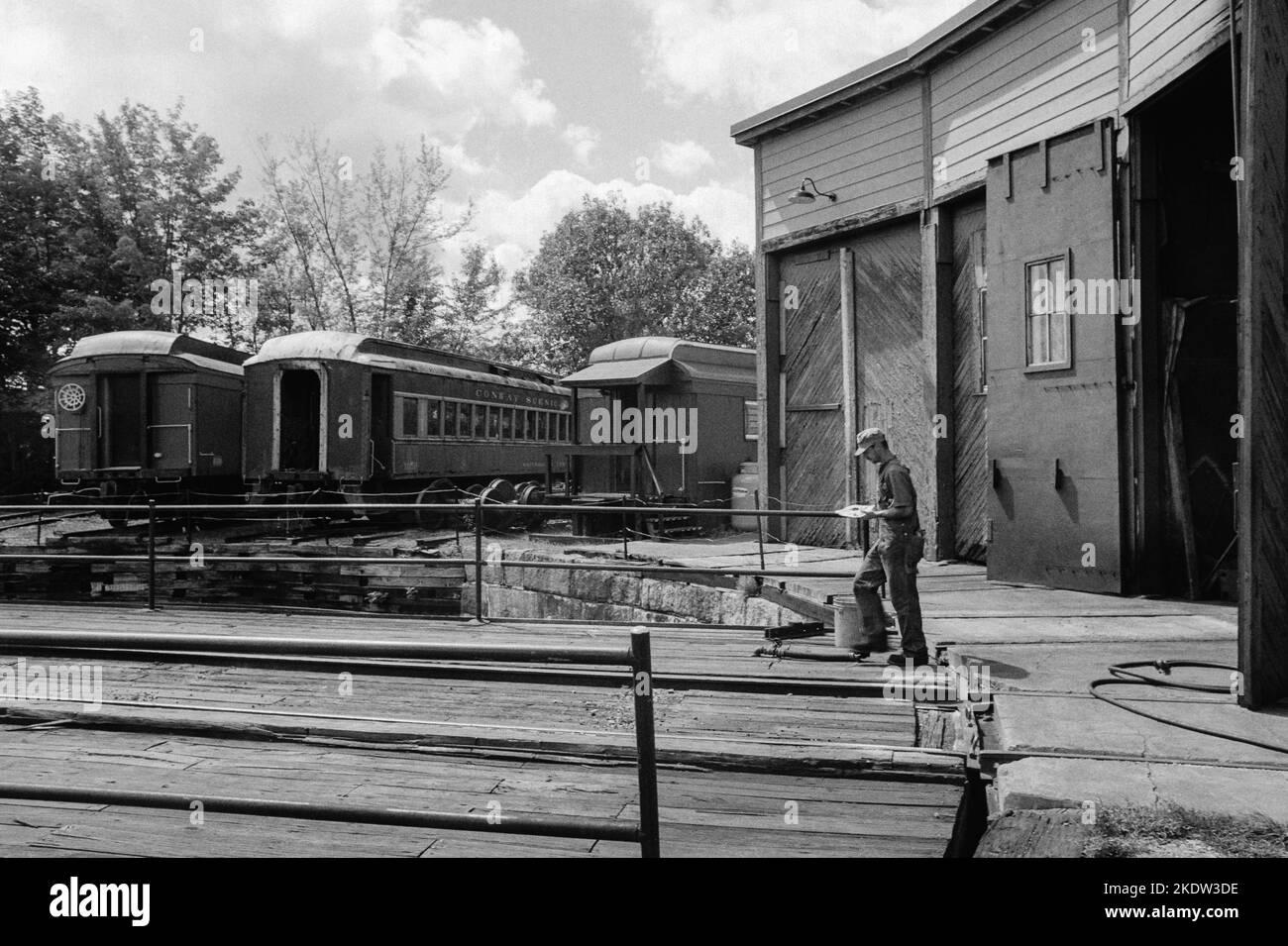 A mechanic exits the roundhouse heading for a train at the Conway