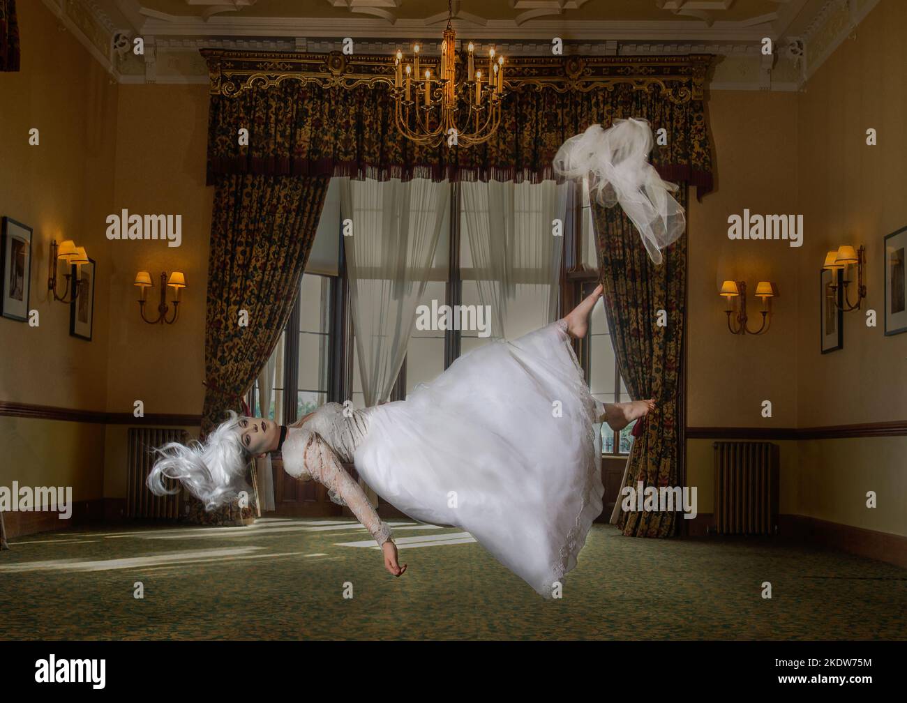 Ghostly bride floating in mid air in a beautiful large room. Haunted house image of a bride levitating in mid air Stock Photo