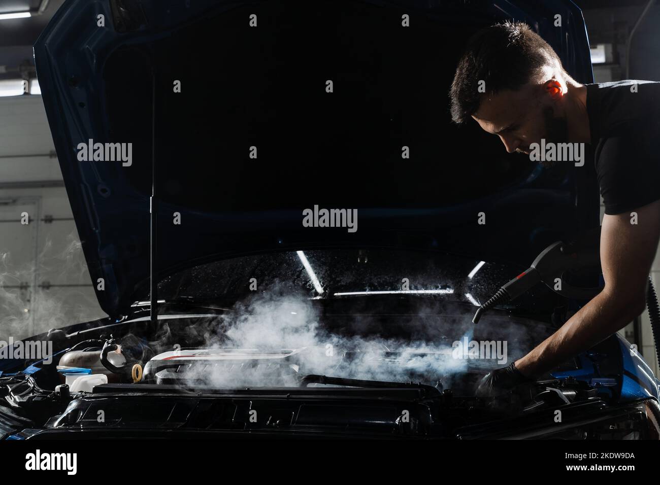Steaming washing of motor of auto in detailing auto service. Process of steam cleaning car