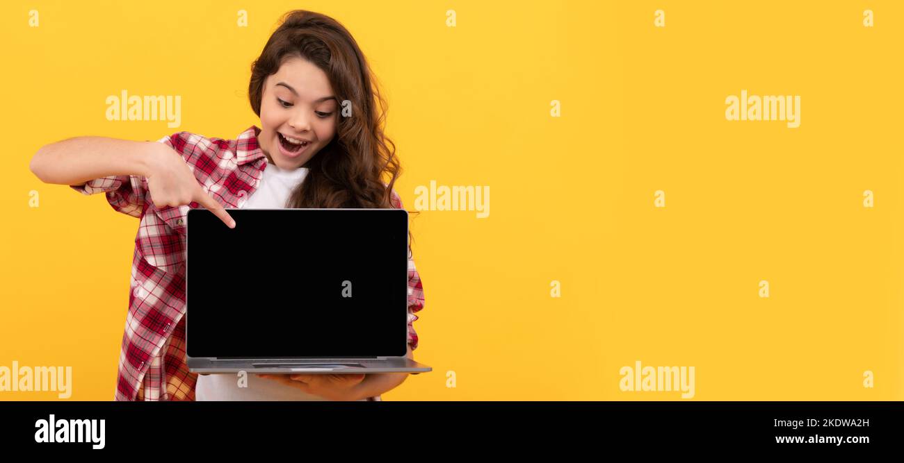 teen girl pointing finger on laptop on head. online education. back to school. webinar advertisement. School girl portrait with laptop, horizontal Stock Photo