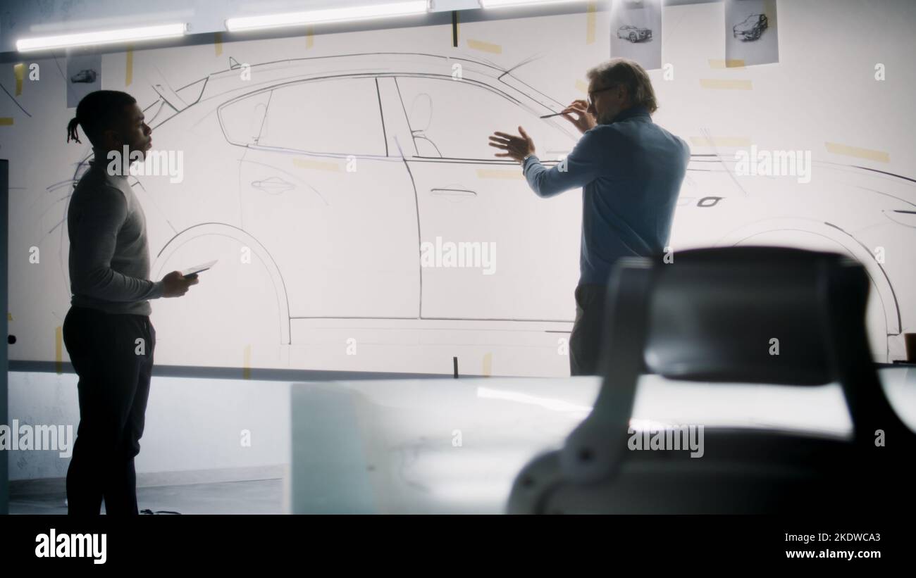 Two diverse automotive male designers discussing and developing