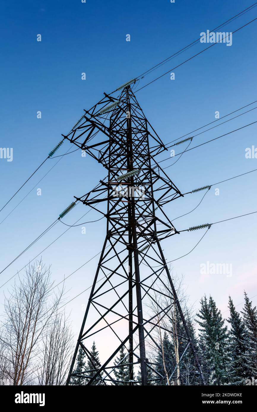 High voltage power pylons against blue sky and sun rays Stock Photo - Alamy