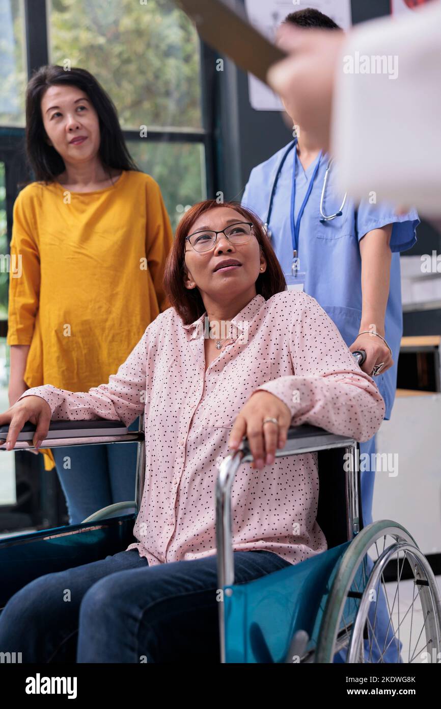 Senior patient in wheelchair having medical appointment talking with