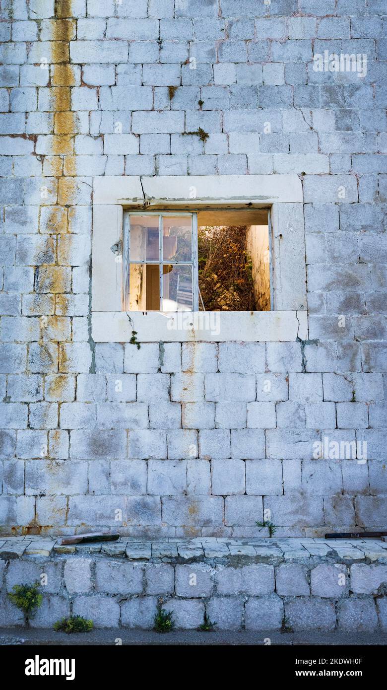 Broken window on abandoned brick building Stock Photo