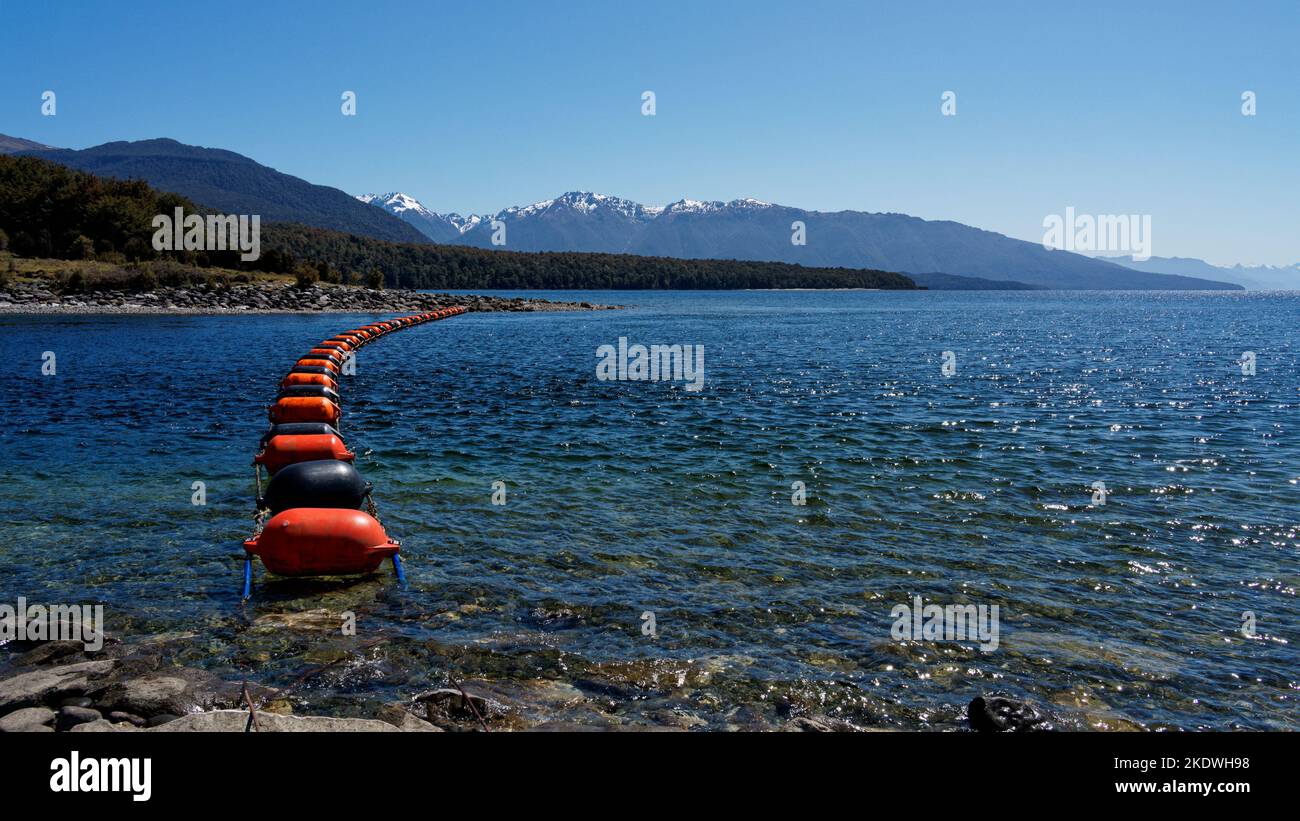 Mussel buoy barrier in front of the Control Gates that control the flow of water between Lake Te Anau and Lake Manapouri. Stock Photo