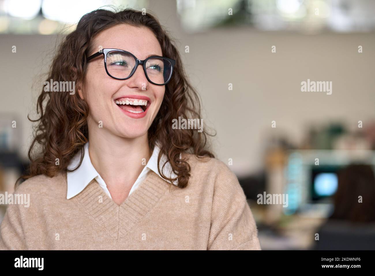 Young relaxed happy smiling pretty professional business woman at workplace. Stock Photo