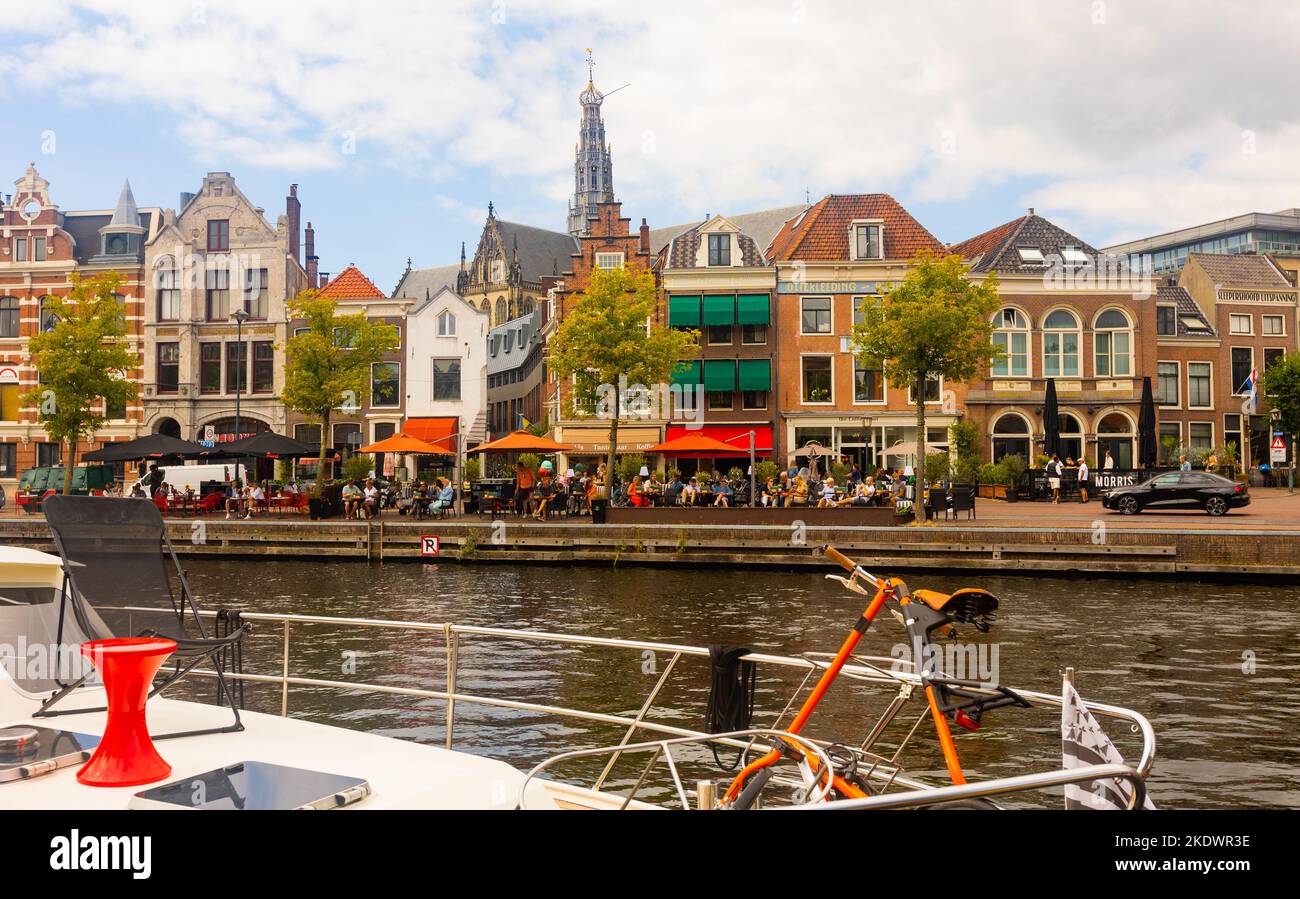 View from pleasure boat of Haarlem waterfront on Spaarne river with Sint-Bavokerk church belfry Stock Photo