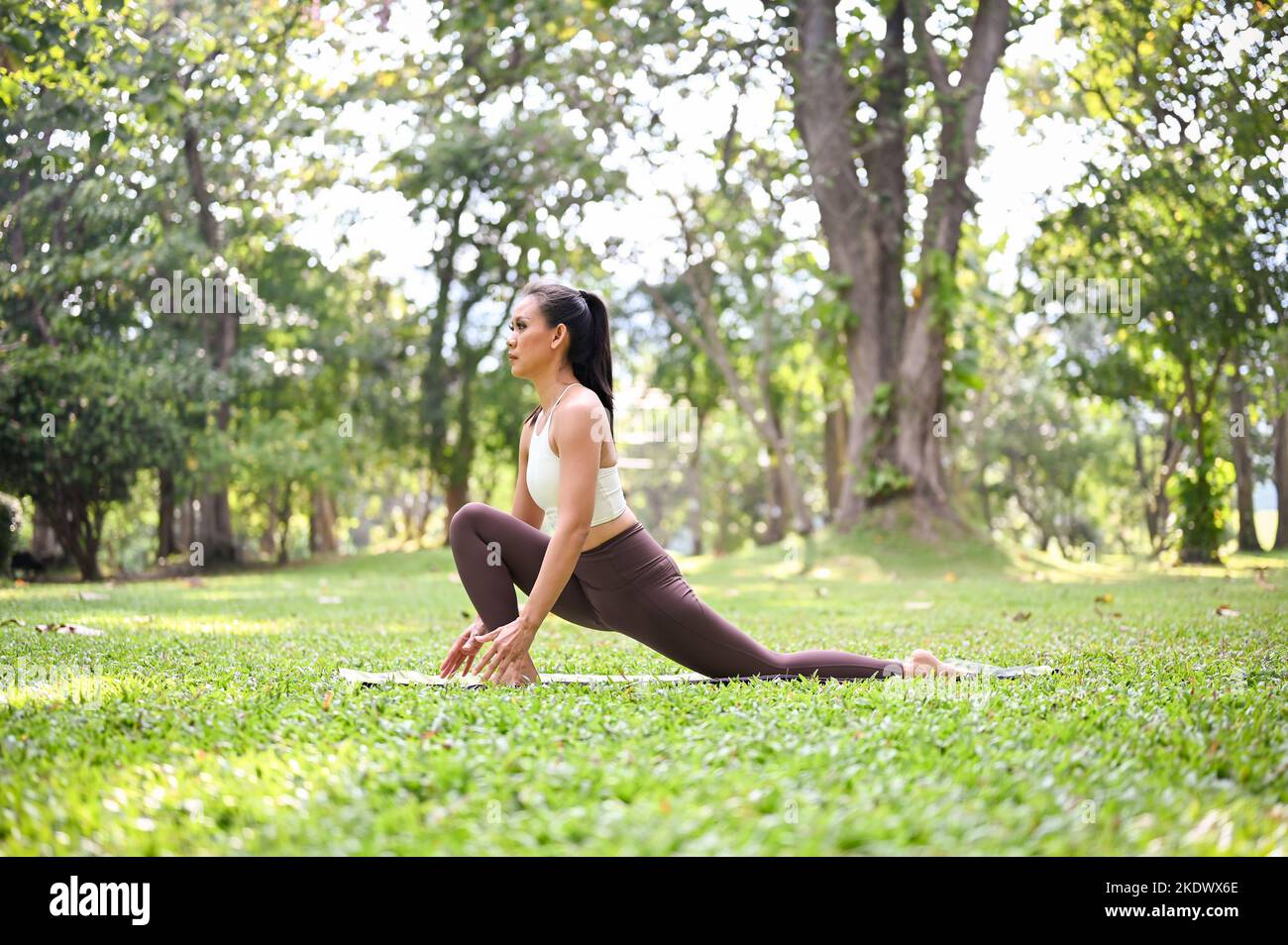 Healthy and beautiful Asian woman in sportswear sitting on her yoga mat ...
