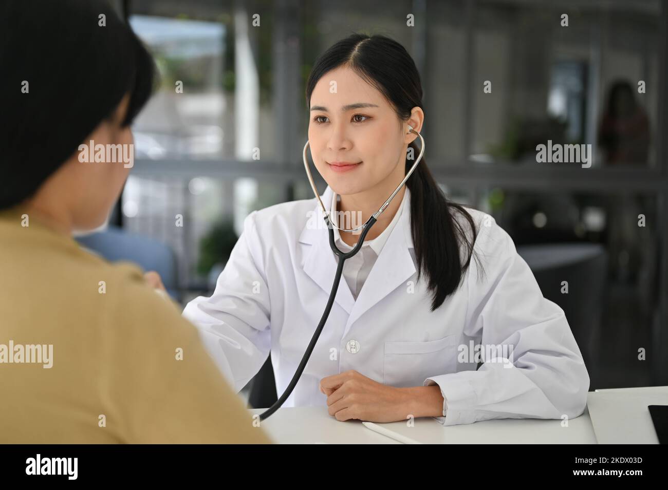 Professional and attractive Asian female doctor using stethoscope to